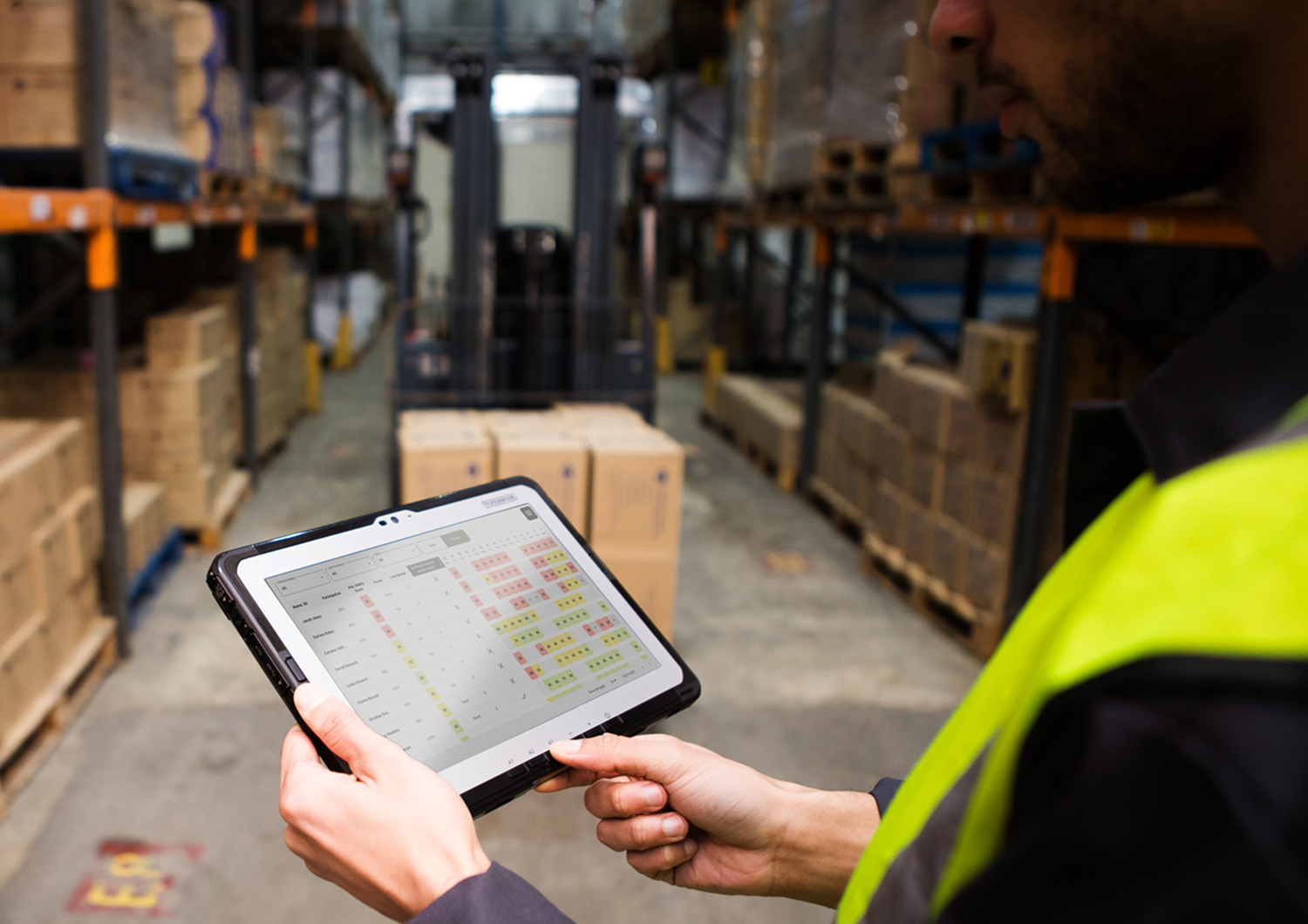 Manager reviewing SafeWork tablet app in warehouse
